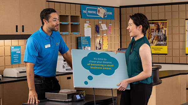 The UPS Store associate displays the customer's new Happy Birthday vinyl banner