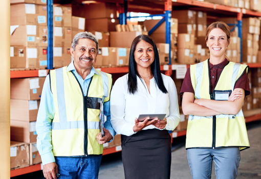 Three people standing in a warehouse.