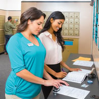 a notary public at The UPS Store helping a customer notarize her documents