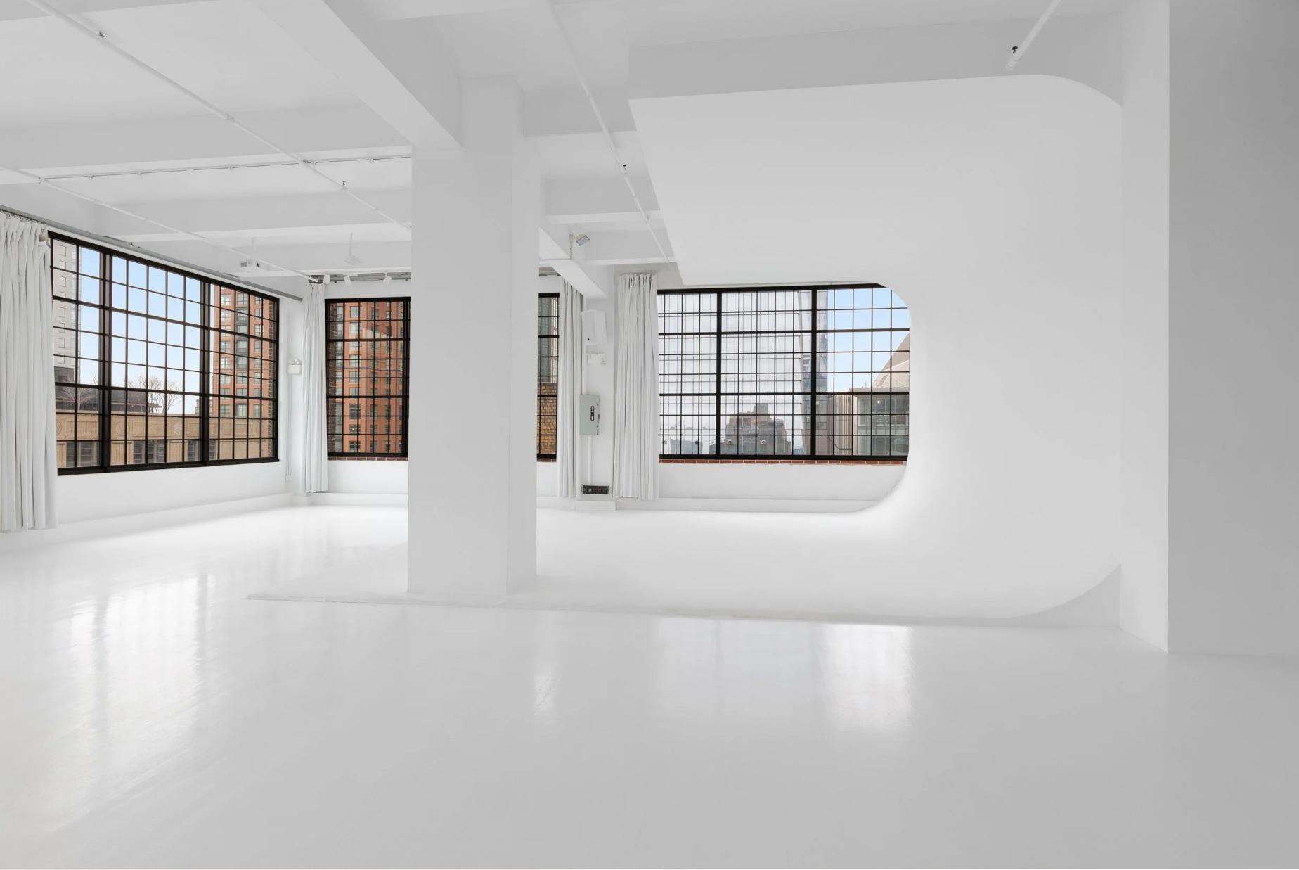 Cyclorama, 10,000 SF Studio 1, Venue Hudson Yards NYC, wrap-around factory sash 14' windows, natural daylight, glossy white floors, 15' ceiling, blackout, photo and film studio rental New York.
