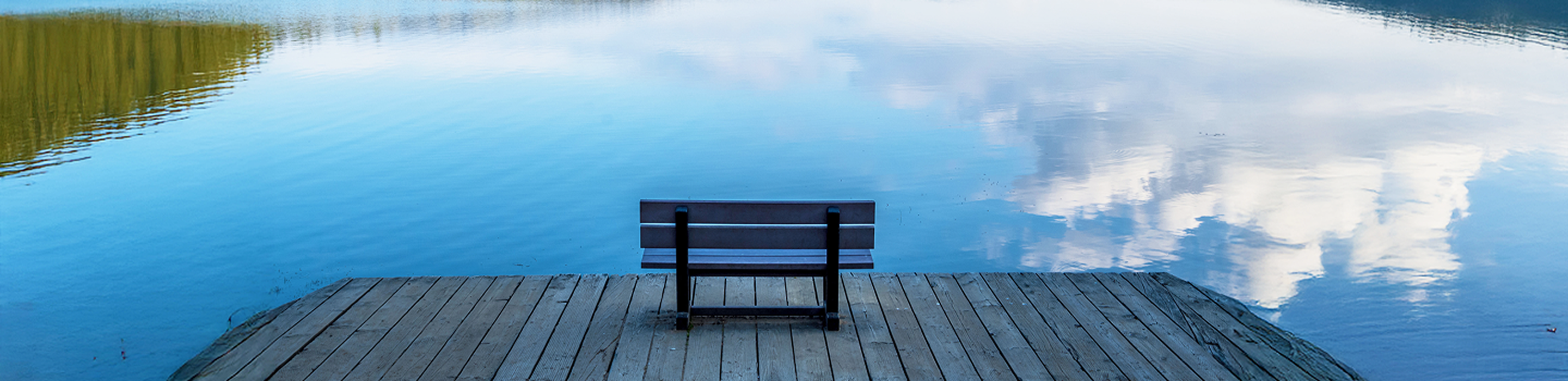 A serene scene of a bench on a boardwalk overlooking La Mauricie National Park.