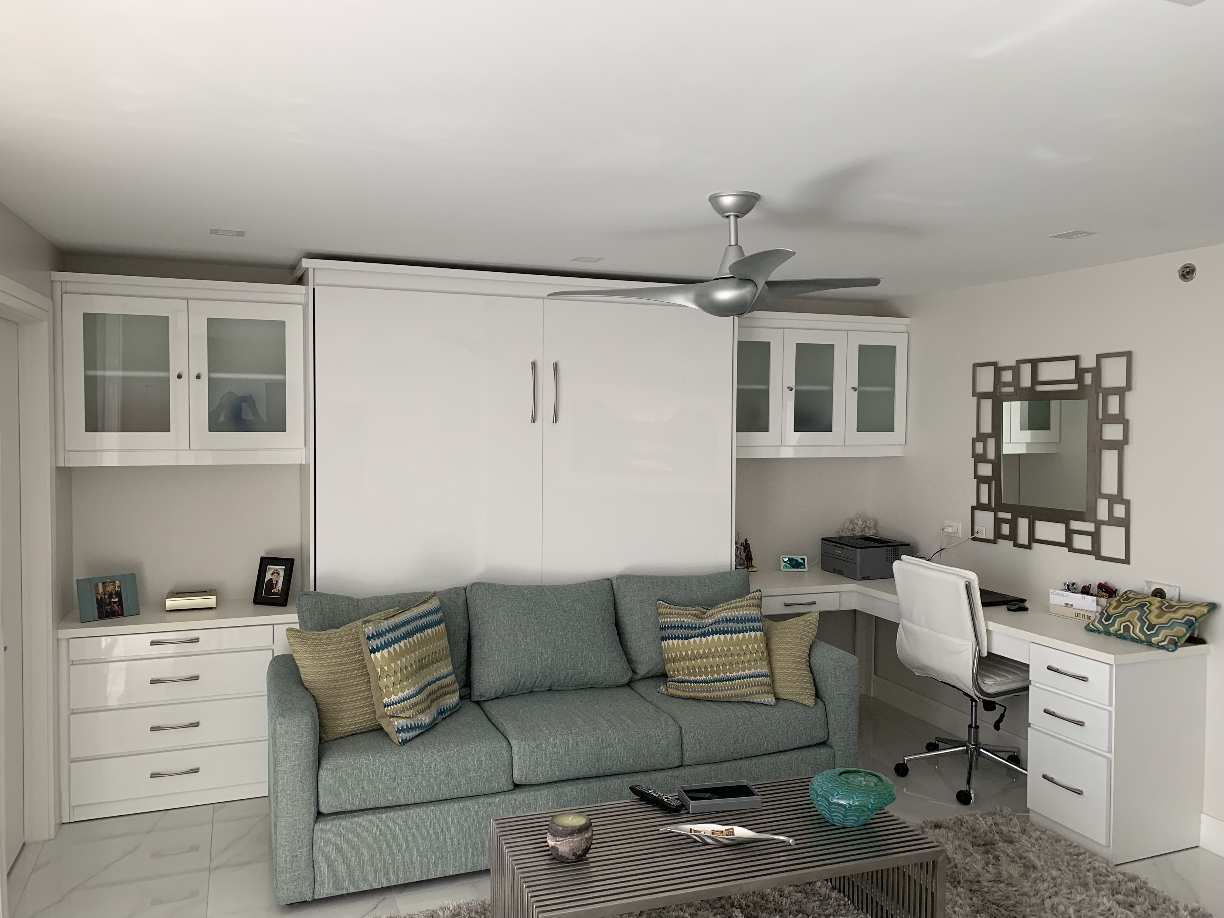 White Murphy bed cabinet with sofa underneath in living room wall unit