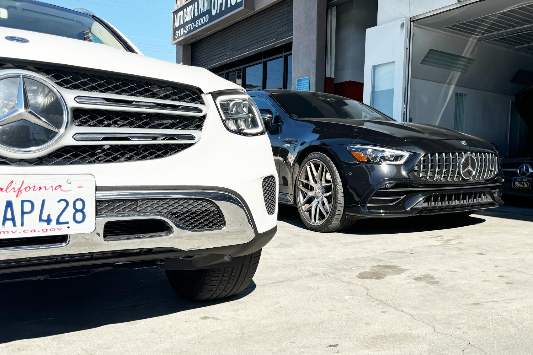 Mercedes Benz White SUV and Black Sedan parked at LUXE Auto Body Shop