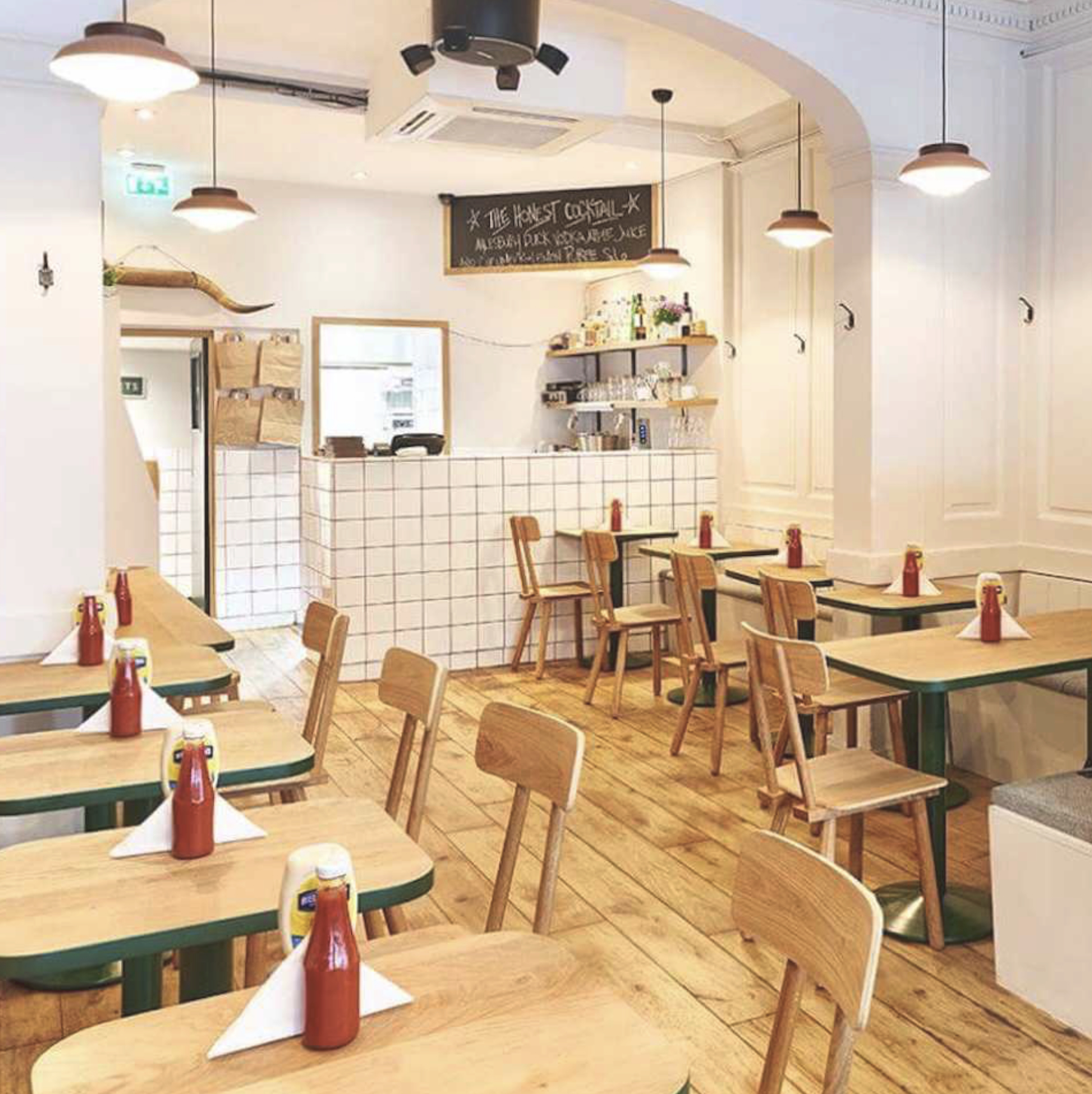 Inviting interior shot of Meard street restaurant showing bright interior with tables and chairs.
