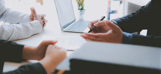Close-up of an advisor discussing documents with a client couple.
