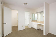 Master vanity with single sink counter, sitting area, medicine cabinet, and walk-in closet.