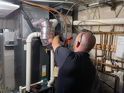 Dean's Home Services Minneapolis HVAC furnace repair service. HVAC Professional works on repairing humidifier and home furnace.