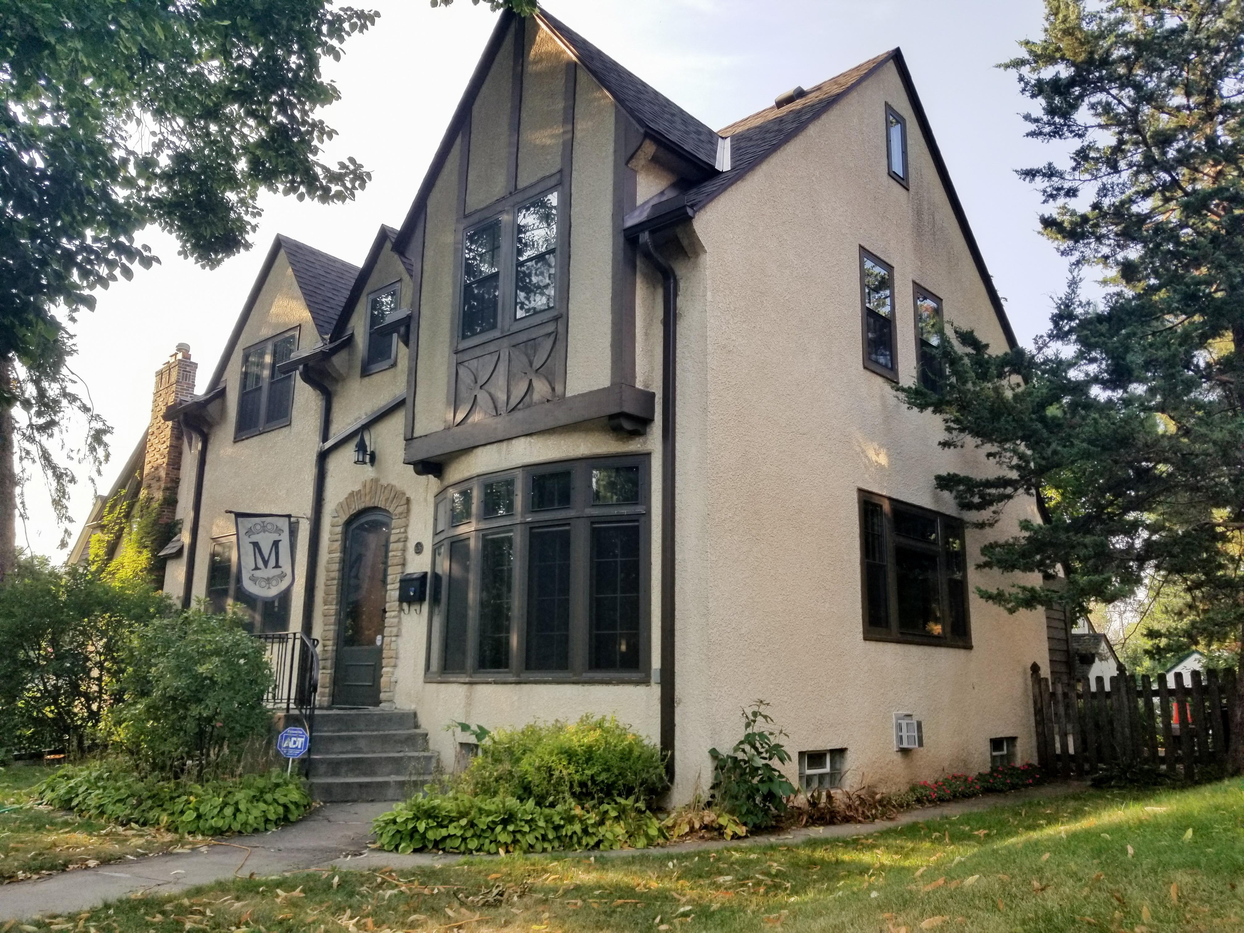 Dark brown custom seamless gutters and downspouts installed to perfectly match a historic Tudor-style home by Ultimate Gutter Solutions.
