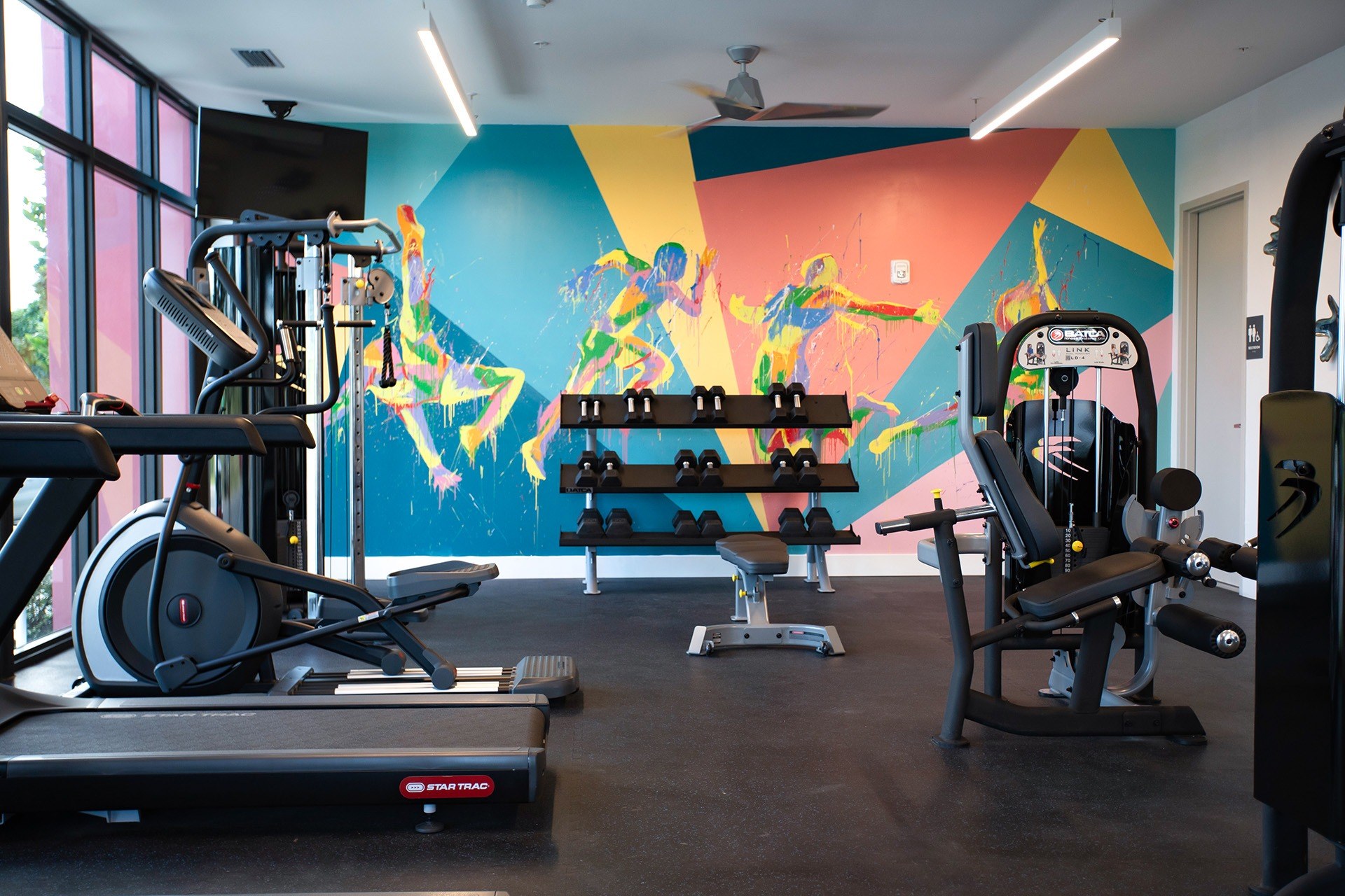 Fitness center with colorful athletic mural