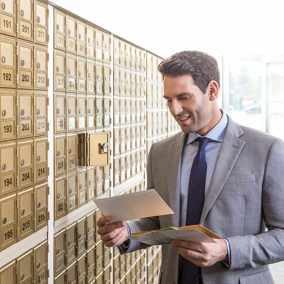 Customer reading letters in front of mailbox