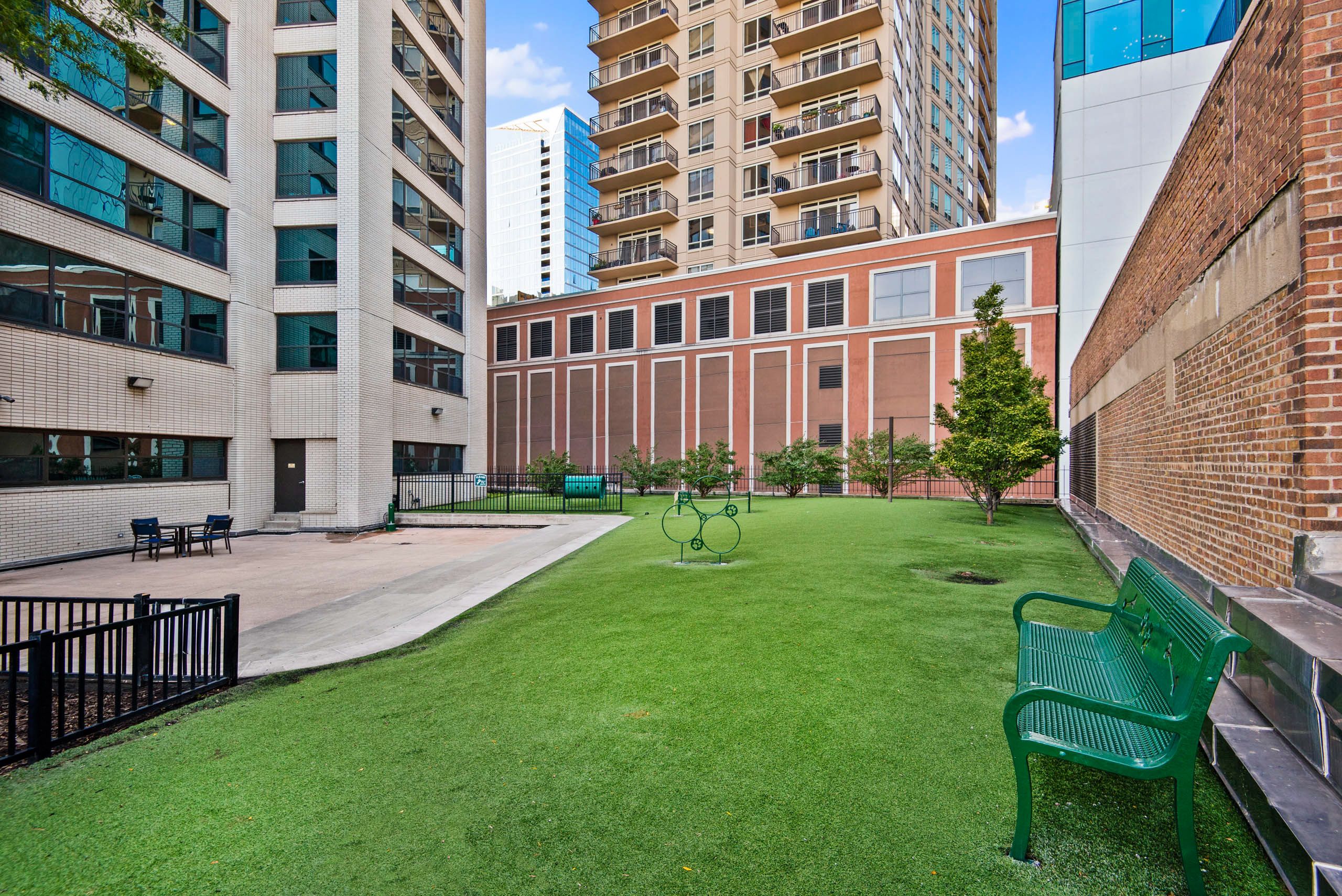 Courtyard green space with seating and landscaped trees 