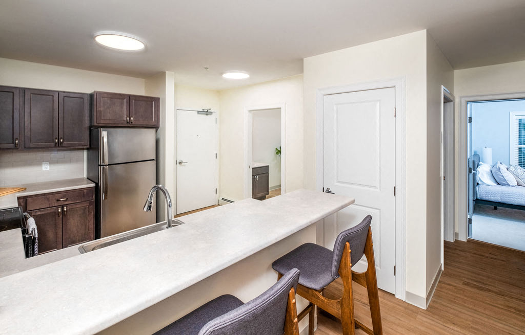 a kitchen with a large counter and a stainless steel refrigerator