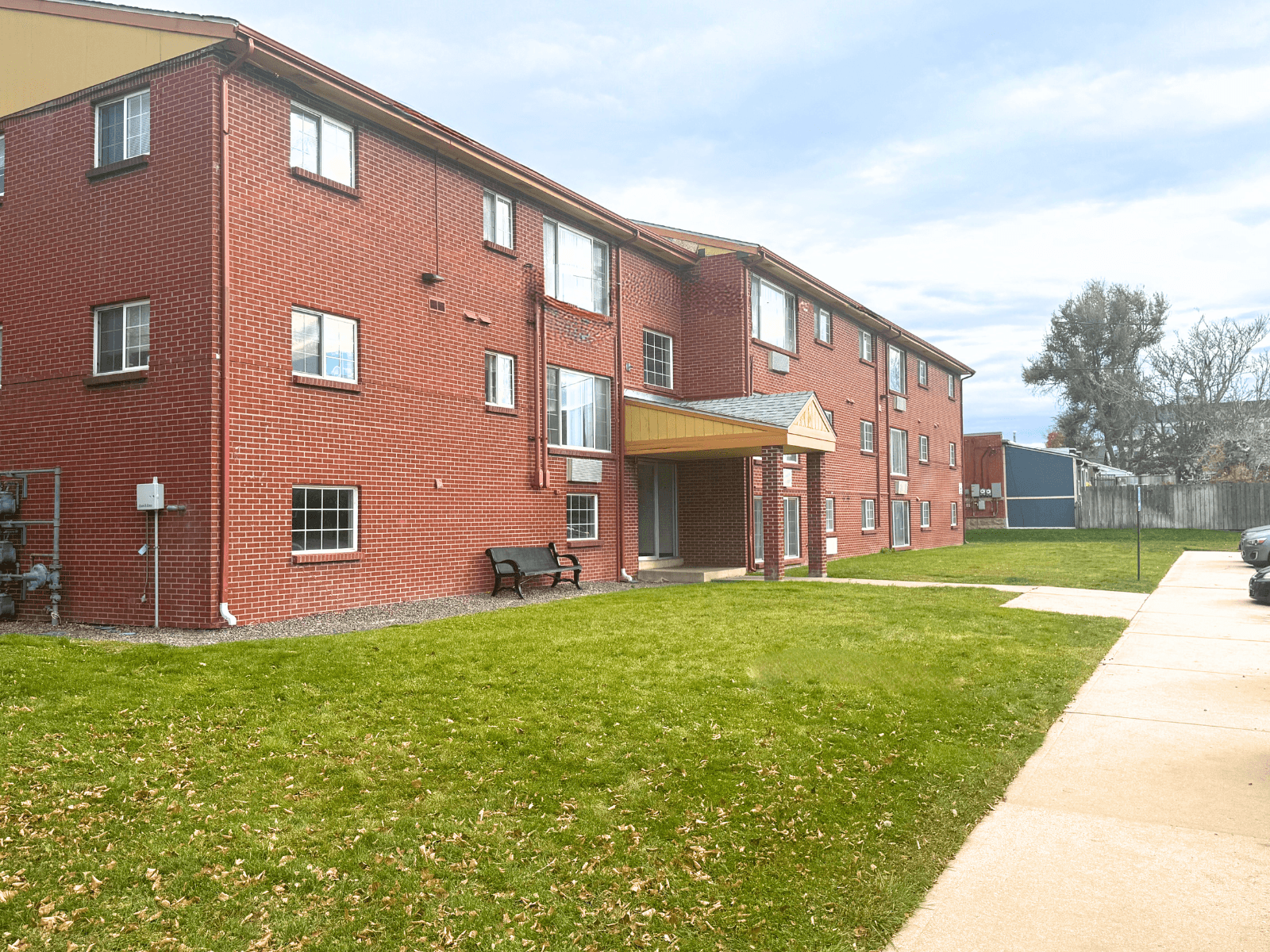 A red brick building with a green lawn in front