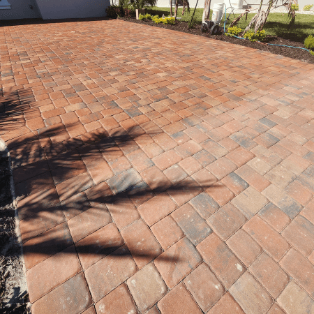 Before and after photo of a paver sealing project in New Smyrna Beach, FL.