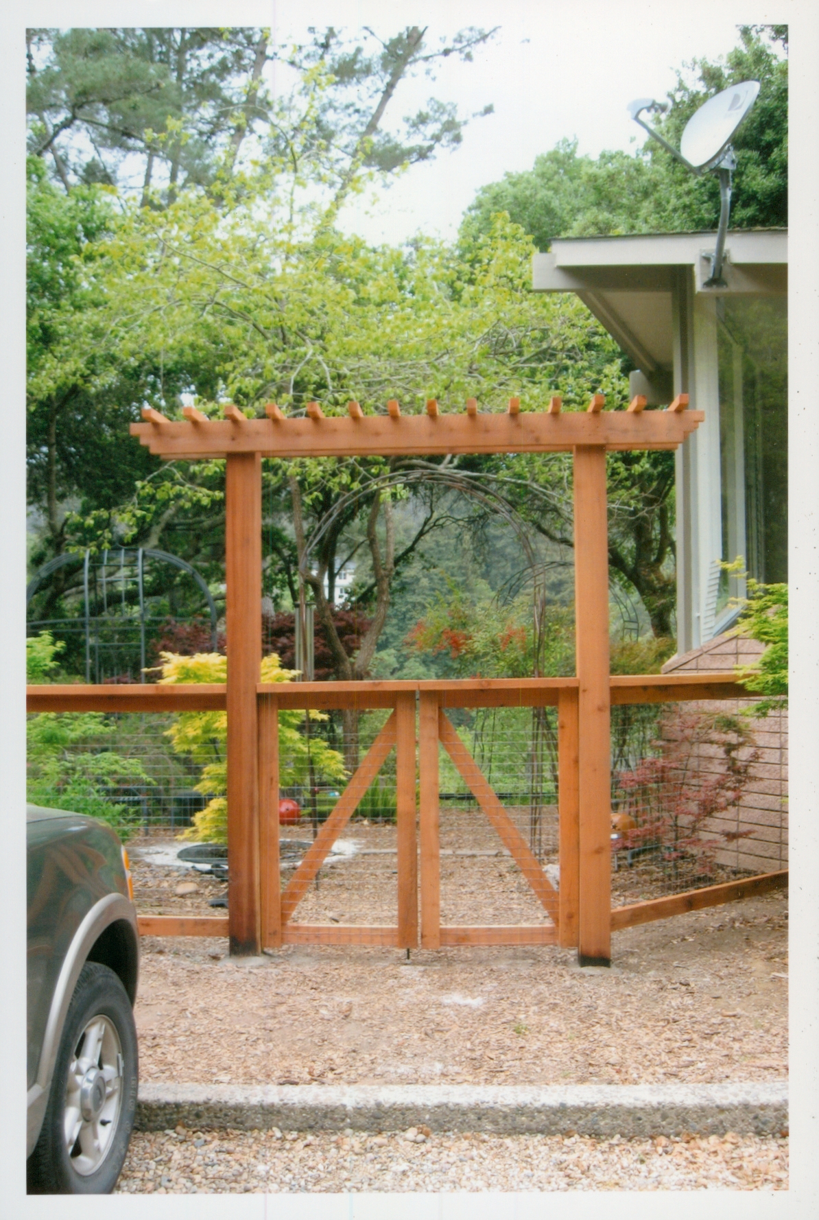 Custom wood arbor and gate installation creating an attractive entryway for a residential property.