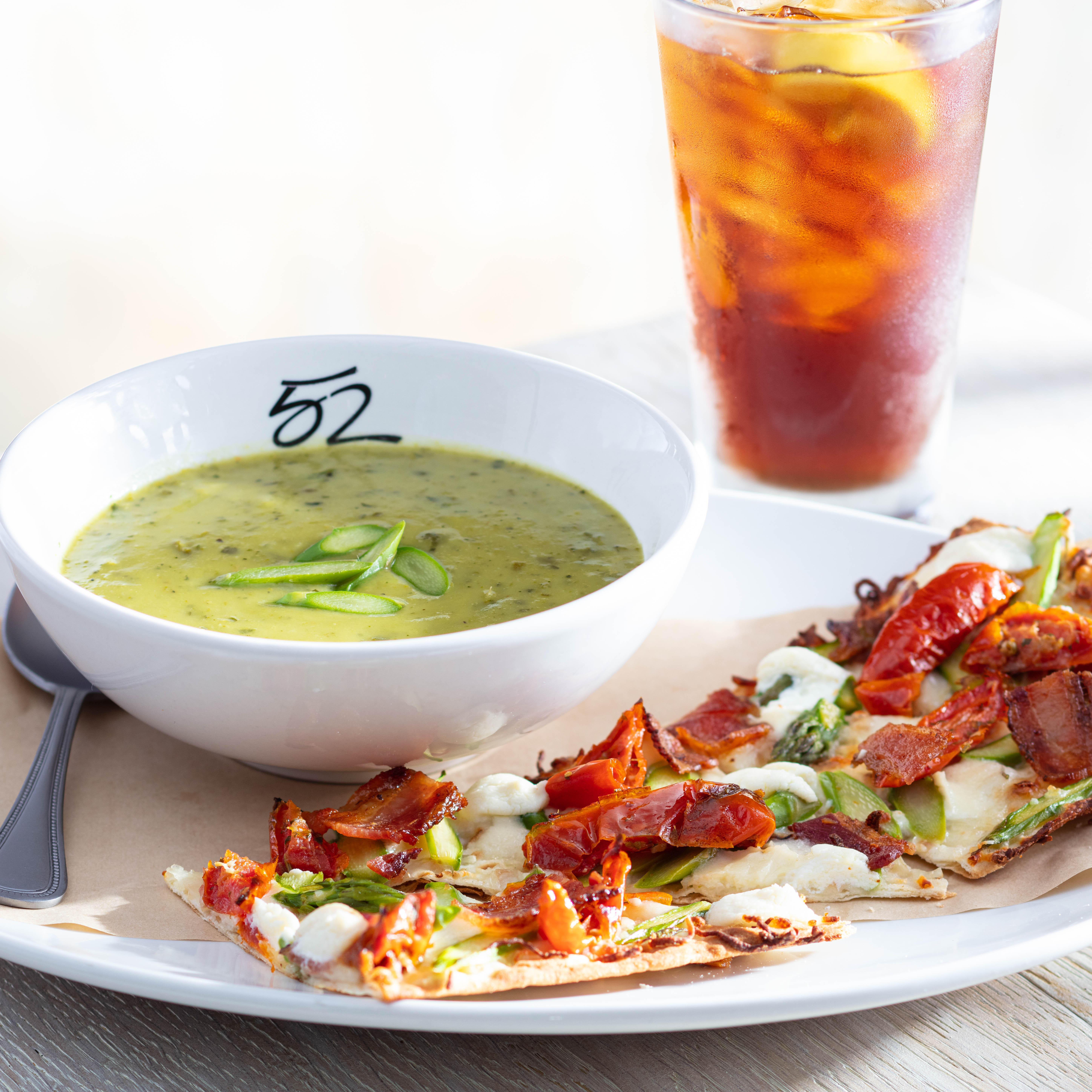 Our seasonal menu offers a variety of lunch pairings of a half flatbread with a soup or salad, as well as entreÌes and handhelds