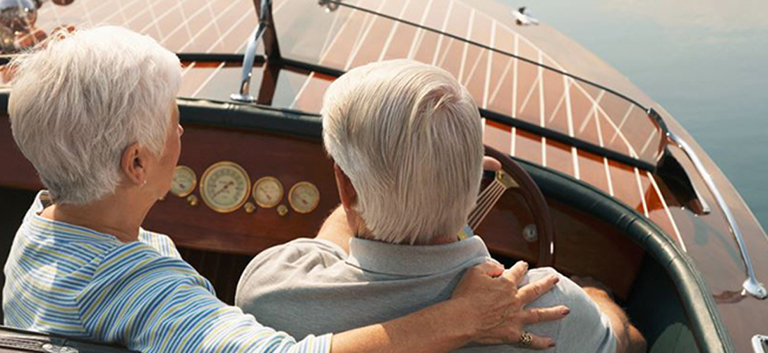 An elderly couple riding their boat on the lake.