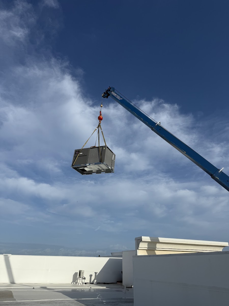 HVAC unit being crane-lifted onto a rooftop for professional commercial installation.