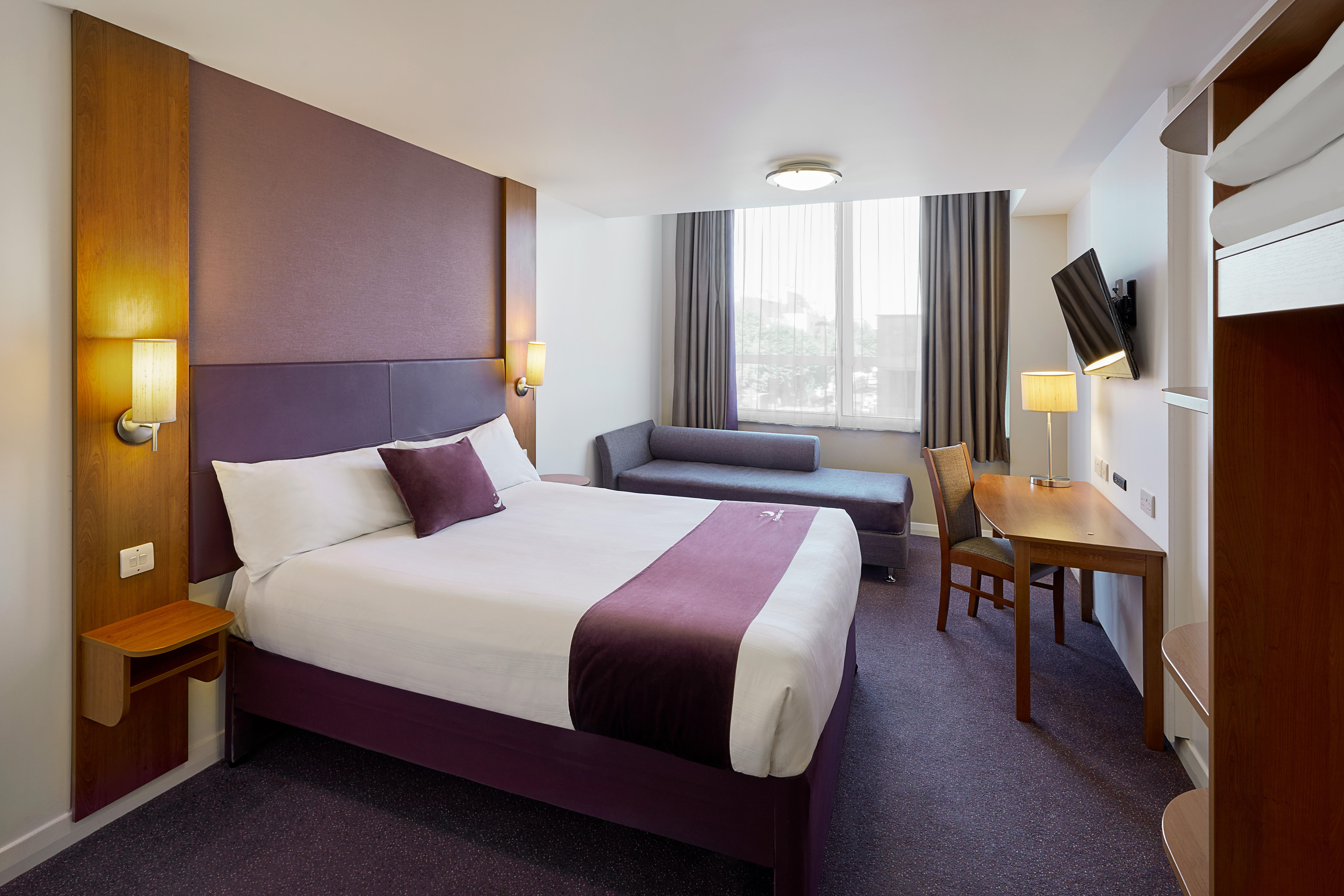 Premier Inn bedroom with double bed, sofa and flat screen TV