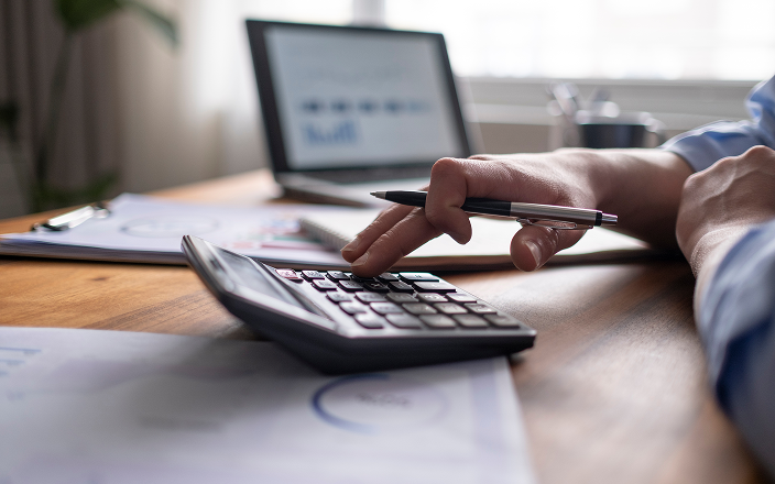 Close-up of a client punching numbers into a calculator.