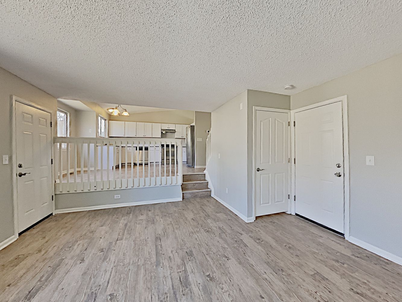 Foyer with white trim, luxury-vinyl flooring in a split-level home at Invitation Homes Denver.