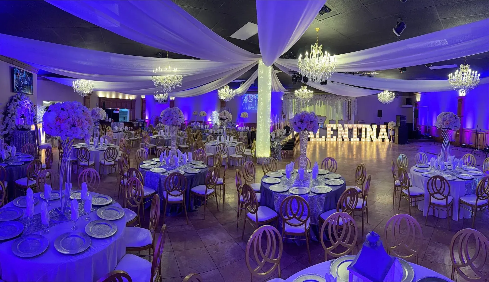 Grand ballroom showcasing luxurious crystal chandeliers, elegant ceiling drapery, beautifully decora 