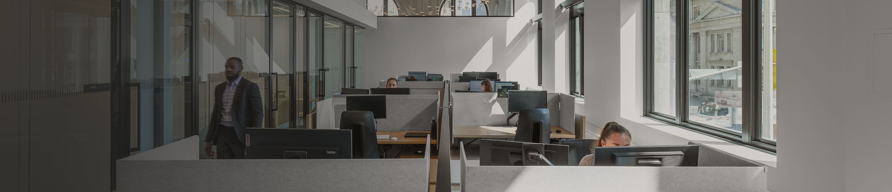 Professionals working at their desks in the modern, bright Ascendant Wealth Partners office.