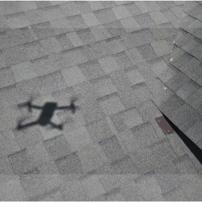 This graphic serves as a primary call-to-action (CTA) on the Pilot Home Inspections website, specifically highlighting our specialized Aerial Drone Inspection services. The image features clean, white typography that reads 'AERIAL DRONE' alongside a detailed visual of a professional inspection drone. This service allows us to safely and thoroughly assess roofs, chimneys, high gutters, and hard-to-access structural elements on residential and commercial properties throughout Southeast Idaho. By using advanced aerial technology, Pilot Home Inspections provides unparalleled detail and accuracy for clients in Idaho Falls, Ammon, Rigby, and Rexburg, ensuring they have a complete understanding of a property's condition before purchasing.
