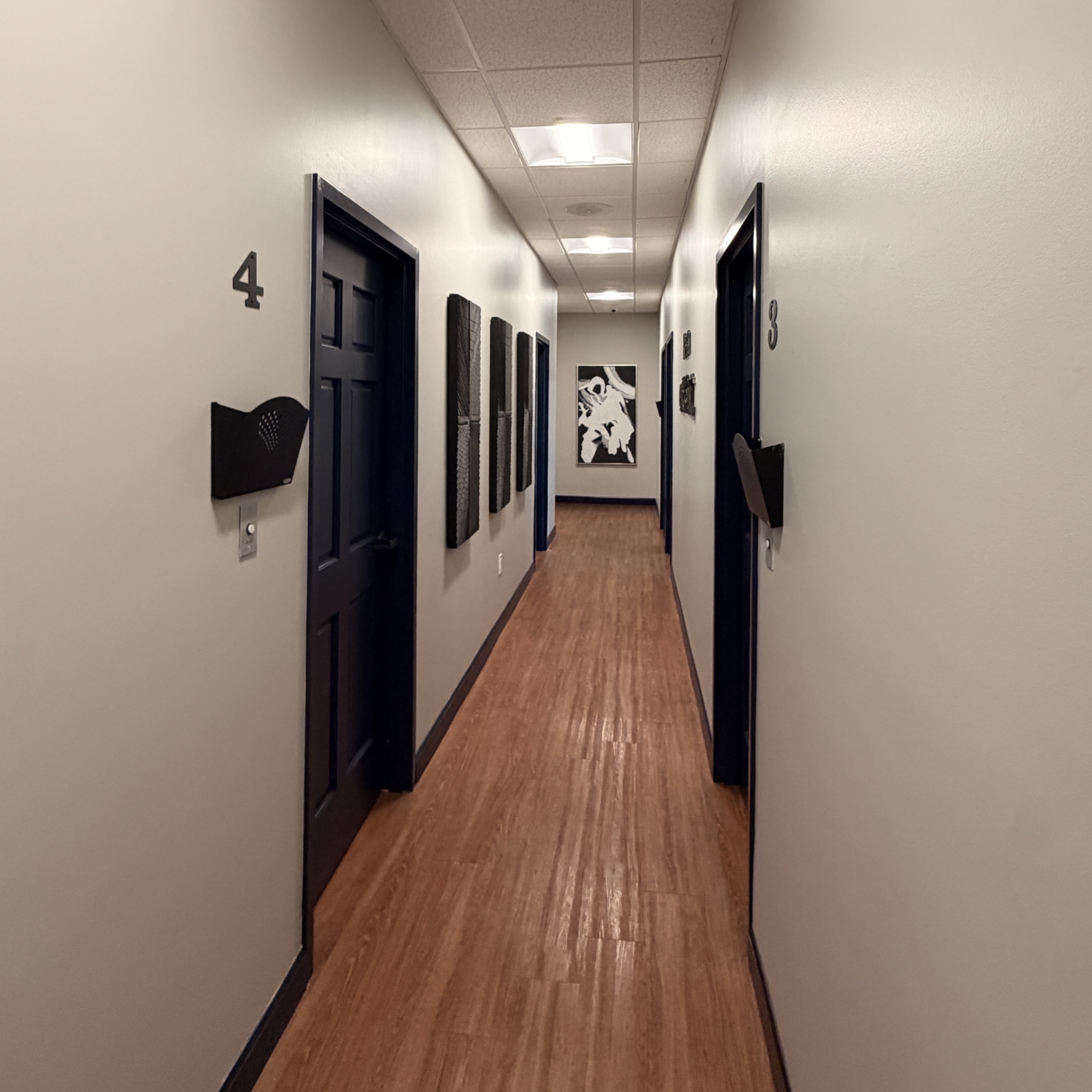 The hallway to our private treatment rooms. It's quiet and calm, with numbered rooms. 