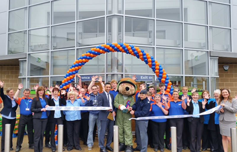 Elgin store being opened by the Help The Heroes Foundation representative FS Tony Walker with Cpl James Magee as their mascot bear who cut the ribbon.