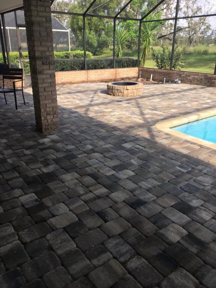 A Four-Corners, Davenport home used pavers in their lanai, pool surround decking, and firepit seating area