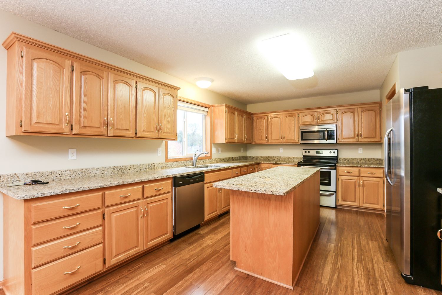 Spacious kitchen with stainless steel and an island at Invitation Homes Minneapolis.