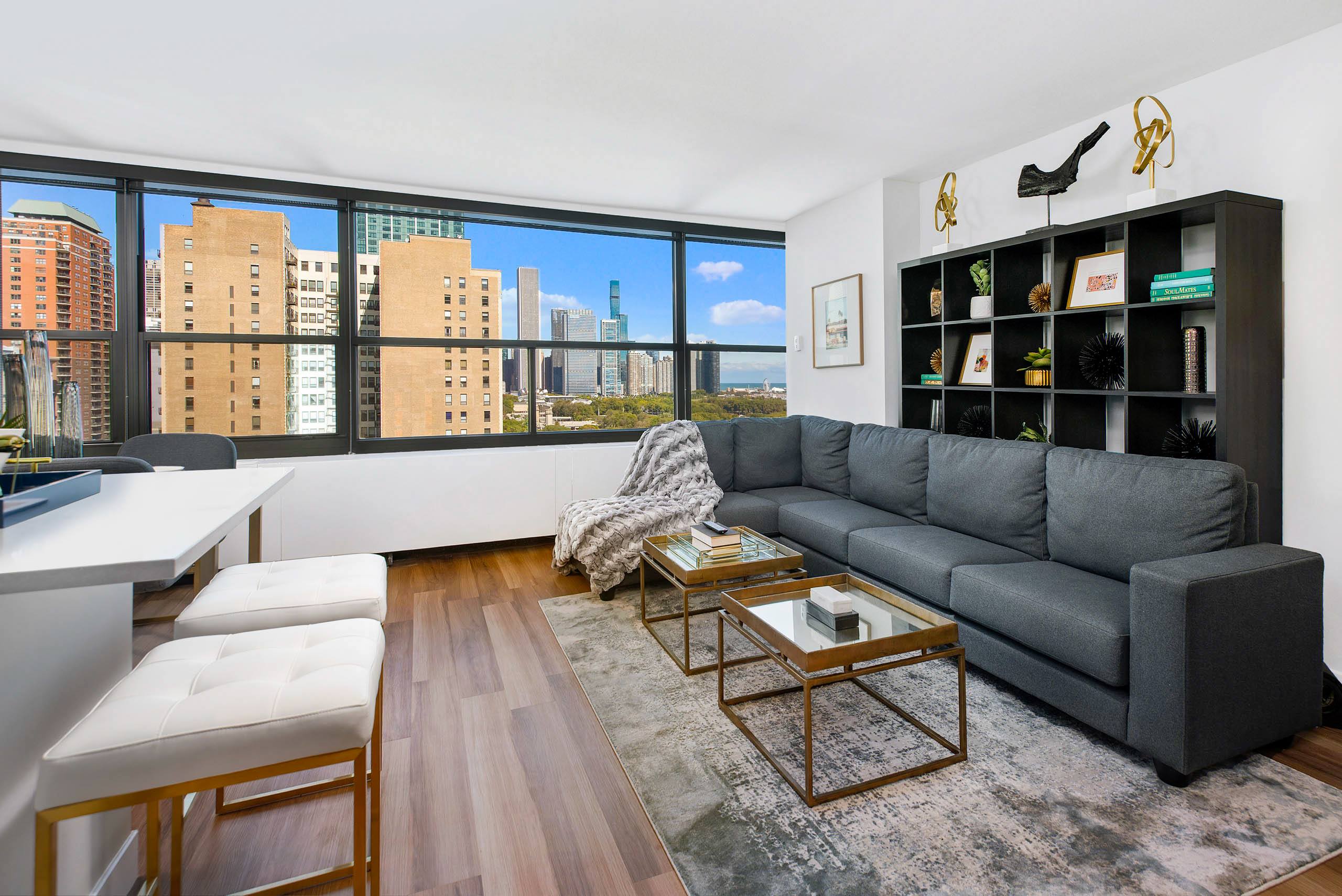 Living room with gray sectional sofa and city skyline views 