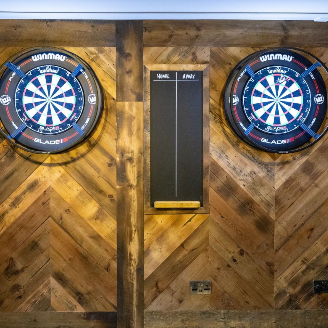 Dedicated darts area with dual boards and central scoreboard, perfect for friendly competition.