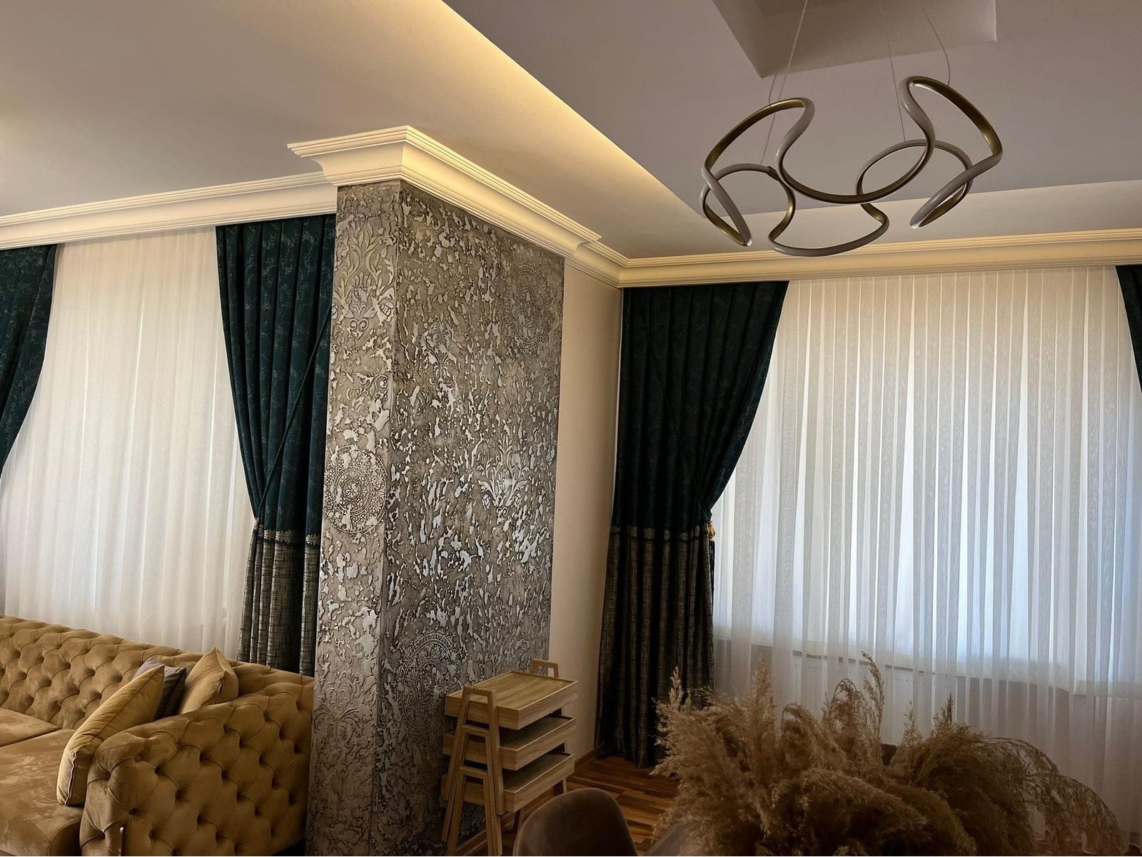 Featuring a textured accent pillar wall, custom crown moulding, and plush curtains, this image showcases Ercon’s attention to detail in interior decor, luxury finishes, and full-room harmony.