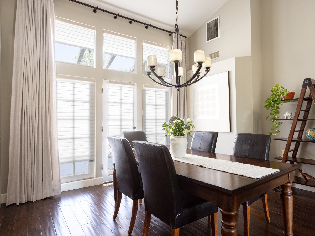 Motorized drapes & shades in a dark and moody dining room.