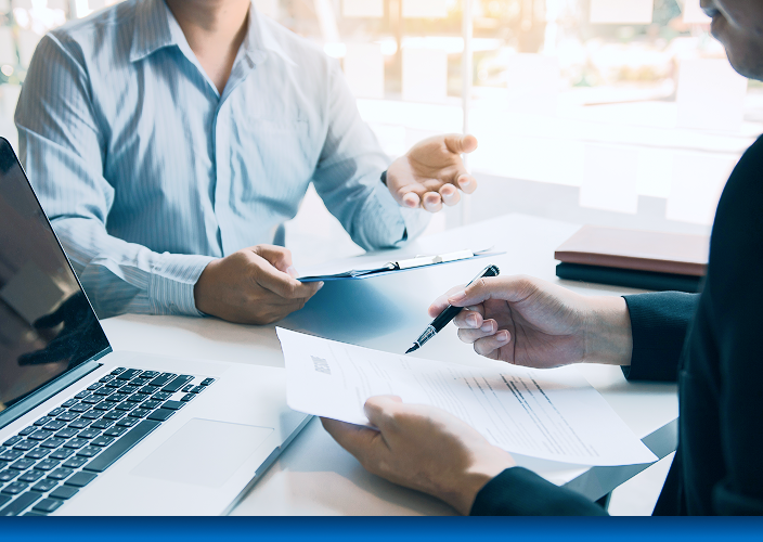 Close-up of two professionals reviewing documents at a desk.