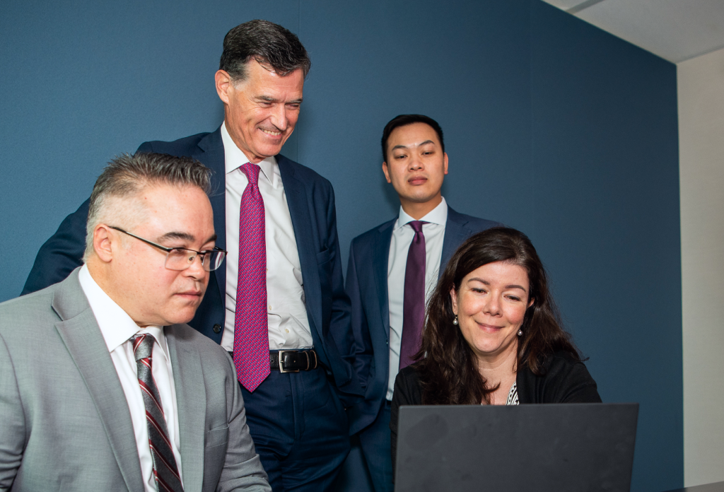 John Grant and team working together at a boardroom table.