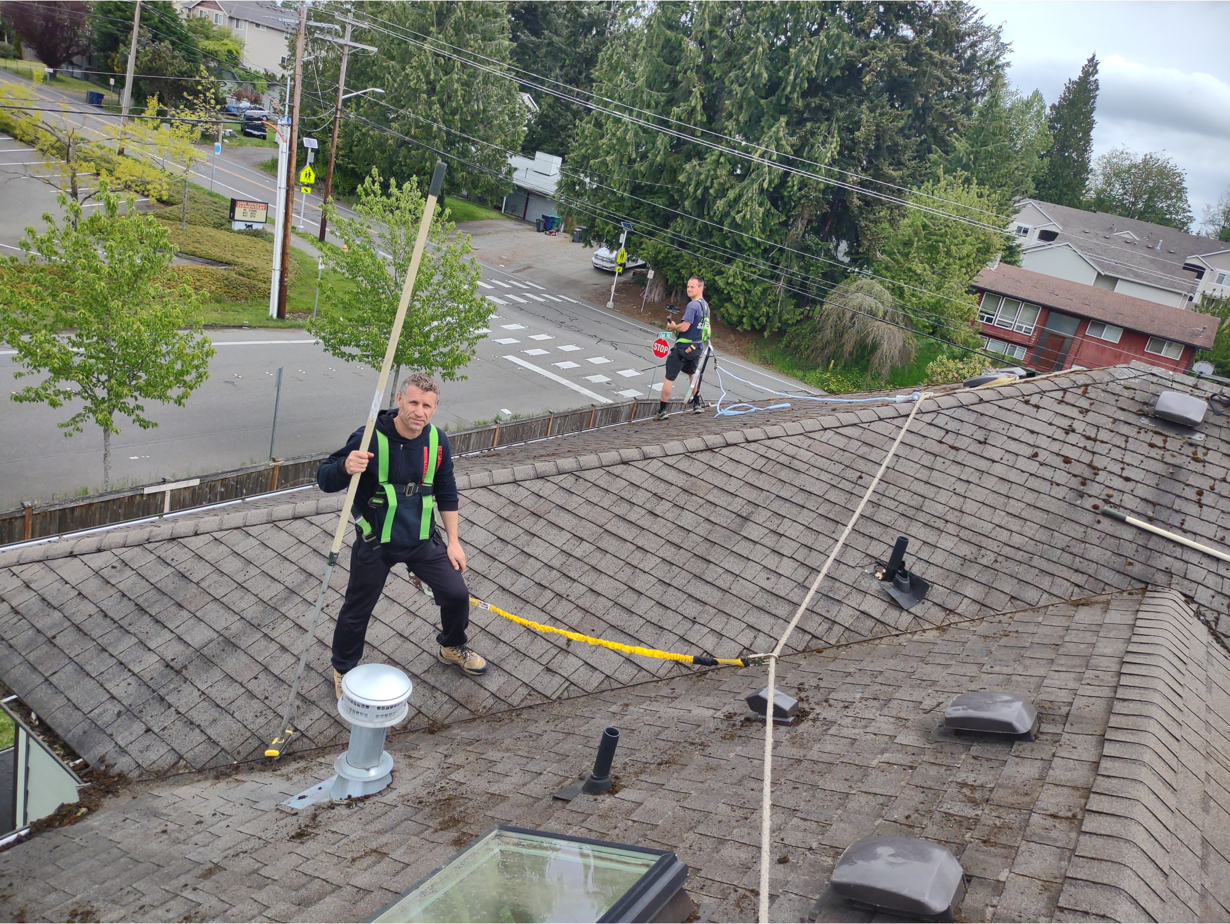 A man on a roof, highlighting the clean and well-maintained surface after roof cleaning.