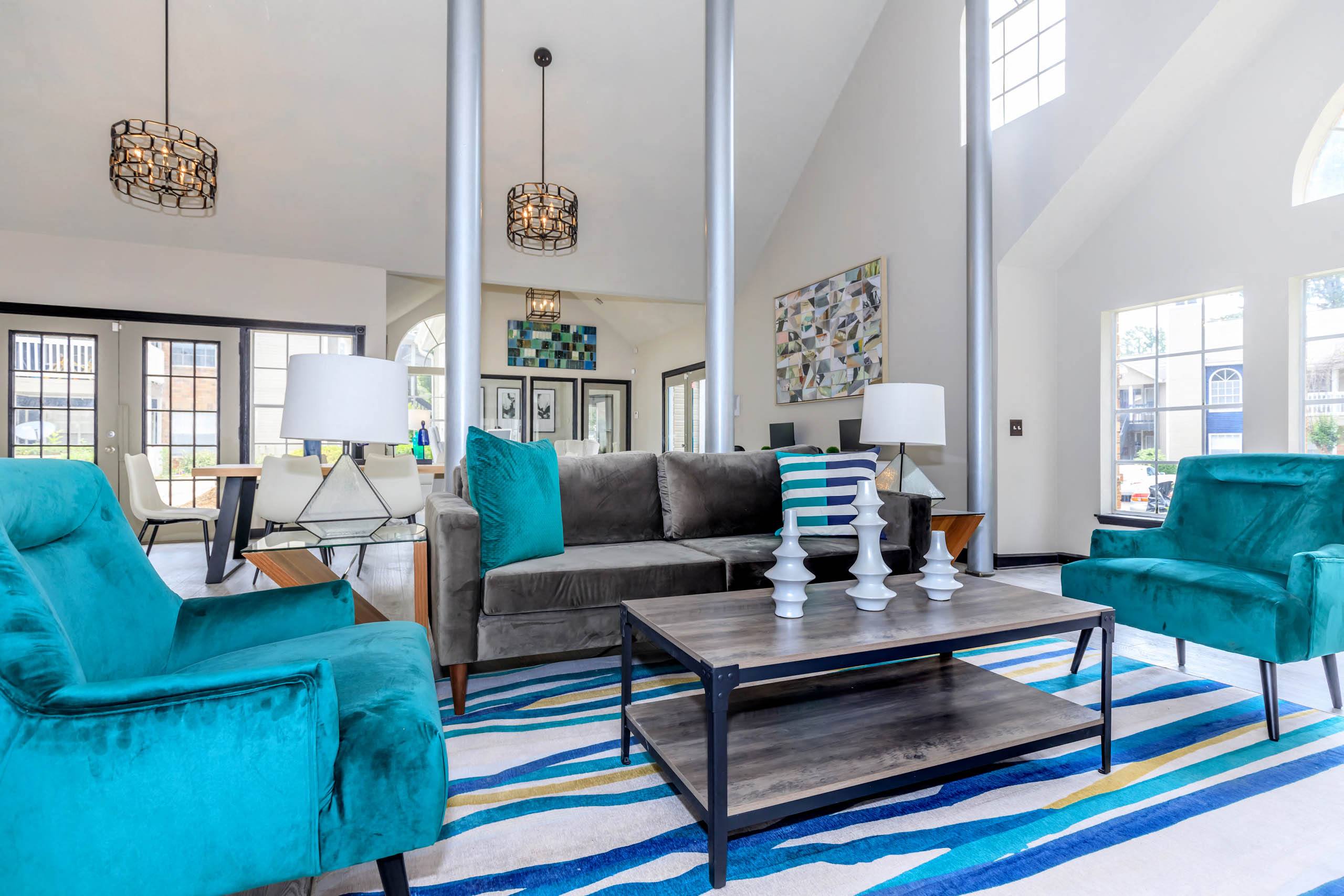 a living room with blue chairs and a gray couch