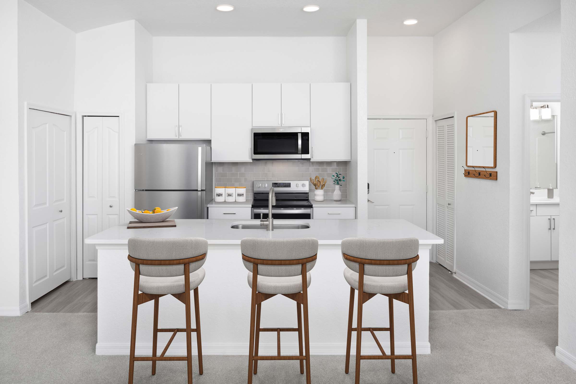 Kitchen with white quartz countertops, white cabinets and gray subway tile backsplash at Camden World Gateway apartments in Orlando, FL