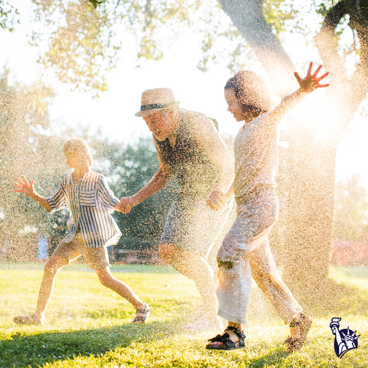 Family playing in sprinklers