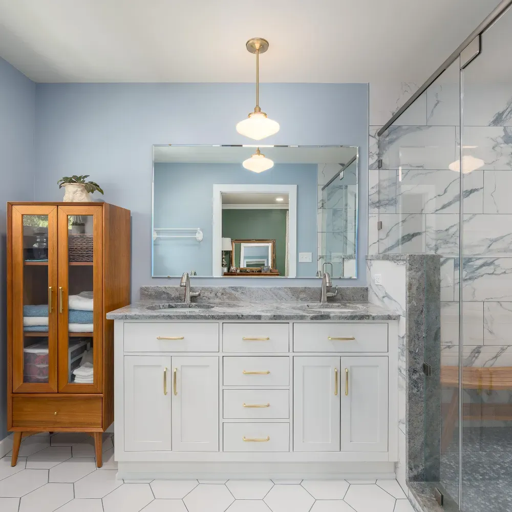 Luxury bathroom remodel near Badin Lake, North Carolina featuring custom white cabinetry, marble countertops, and a glass walk-in shower. This project showcases high-end bathroom renovation craftsmanship by a professional residential remodeling contractor.