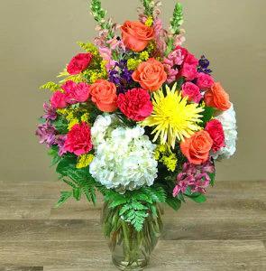 A lovely collection of all our favorite flowers designed in a clear glass vase. Featuring imported roses along side hydrangea, fragrant stock, long lasting carnations and more. Each day we will use the freshest flowers in bright bold colors, exact flowers may vary.