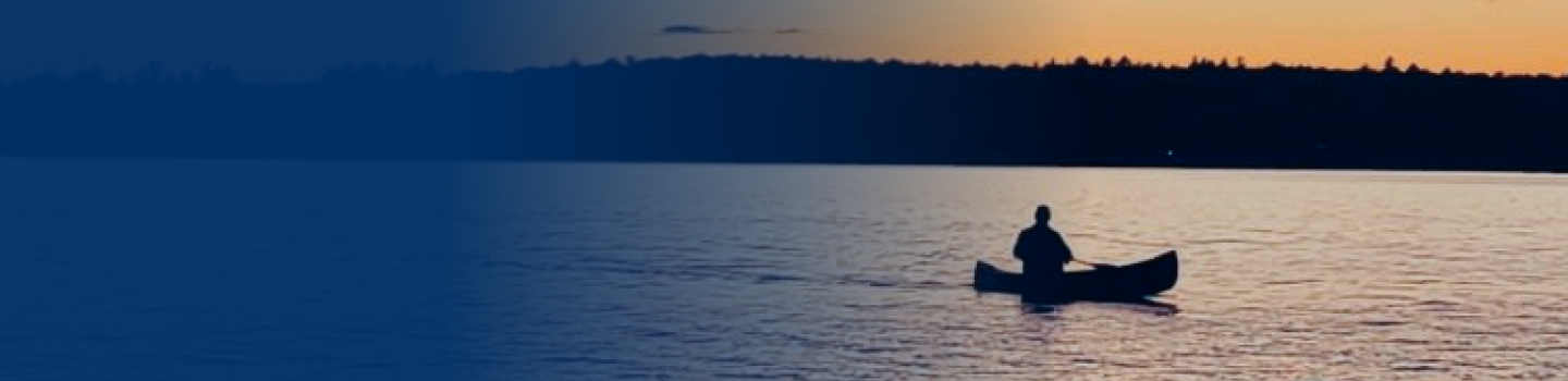 A canoer on the lake at dusk.