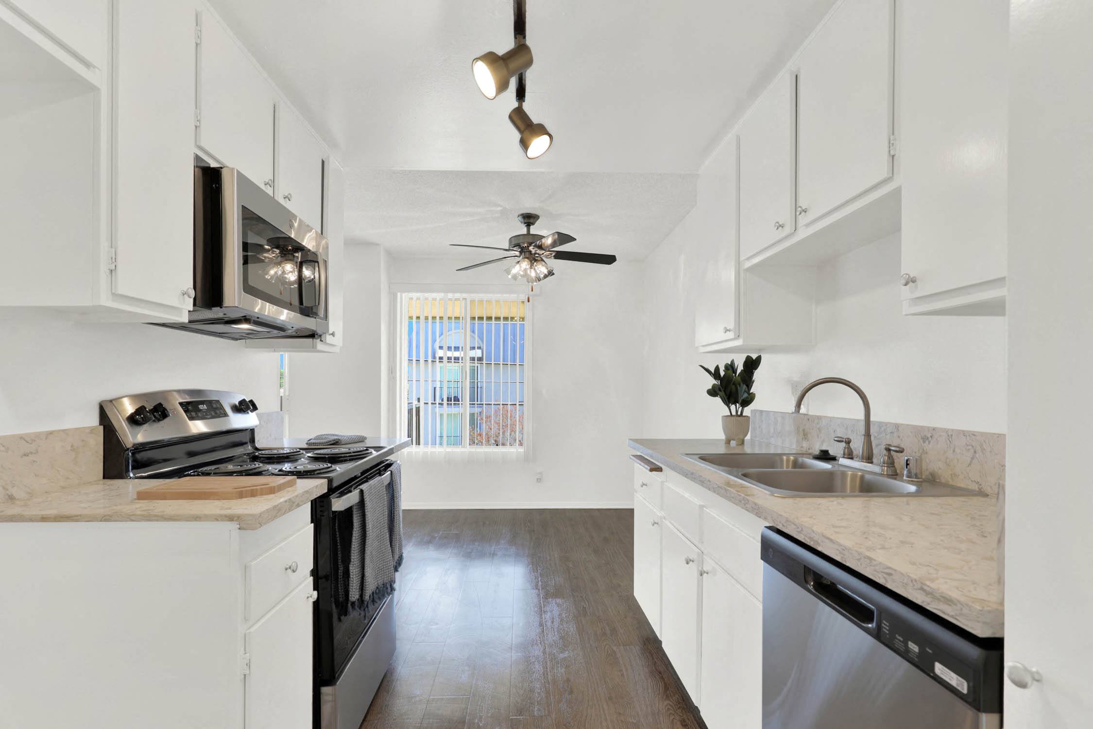 a kitchen with white cabinets and stainless steel appliances