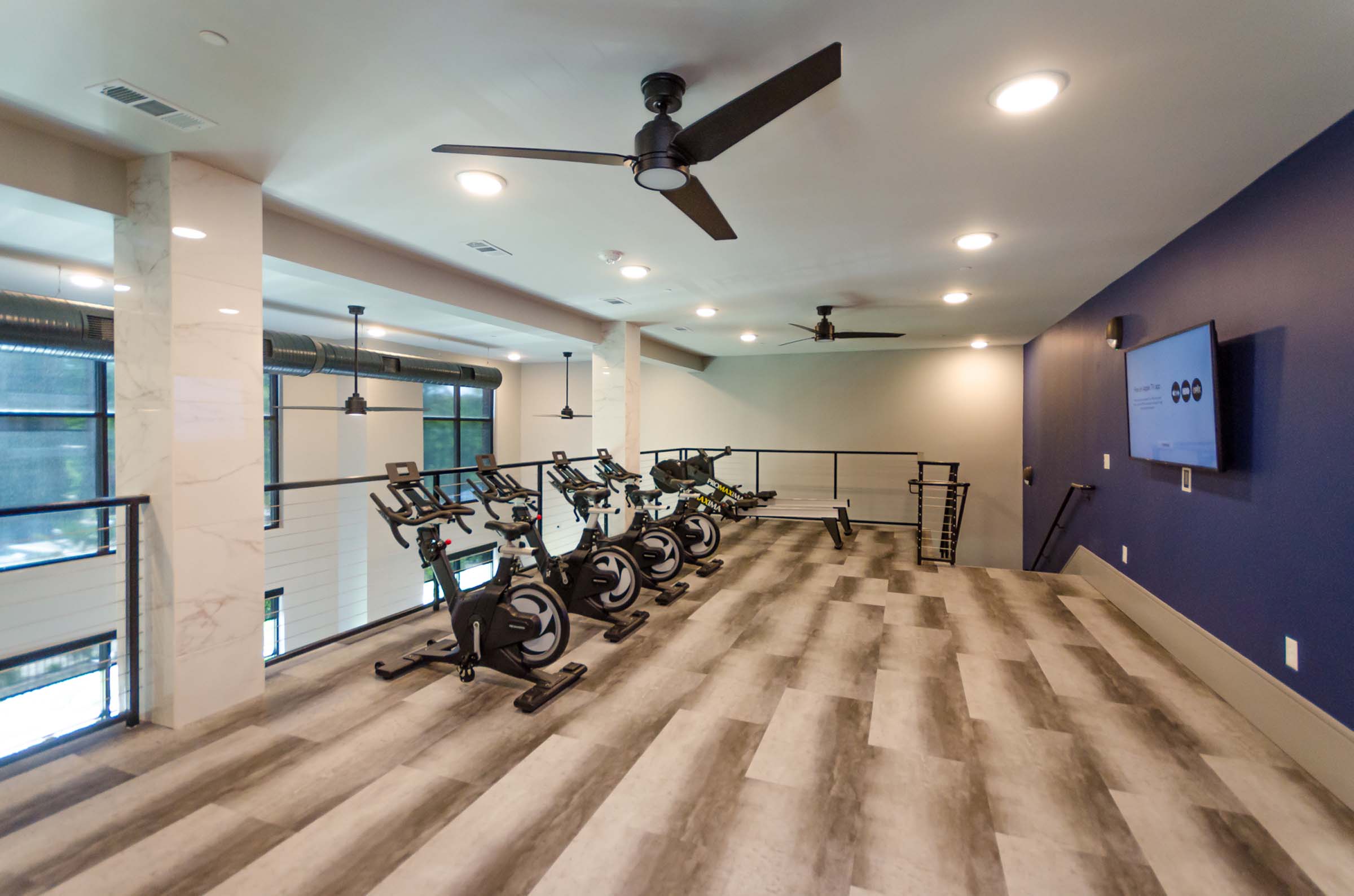 Second floor fitness center with cycle and rowing equipment at Camden Alpharetta apartments in Alpharetta, GA