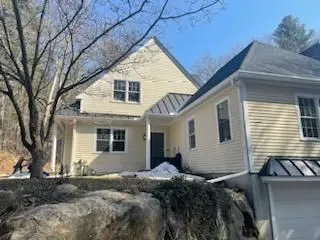 Residential property featuring newly installed gutters and roofing components. Exterior improvements 