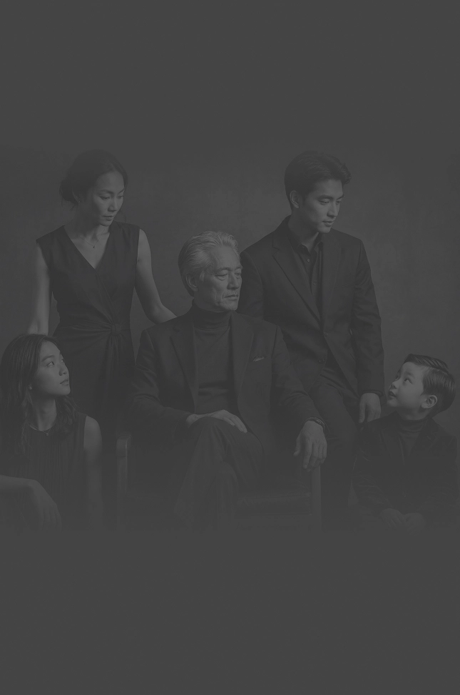 A black and white photo of a family with the father seated and his wife and children around him.