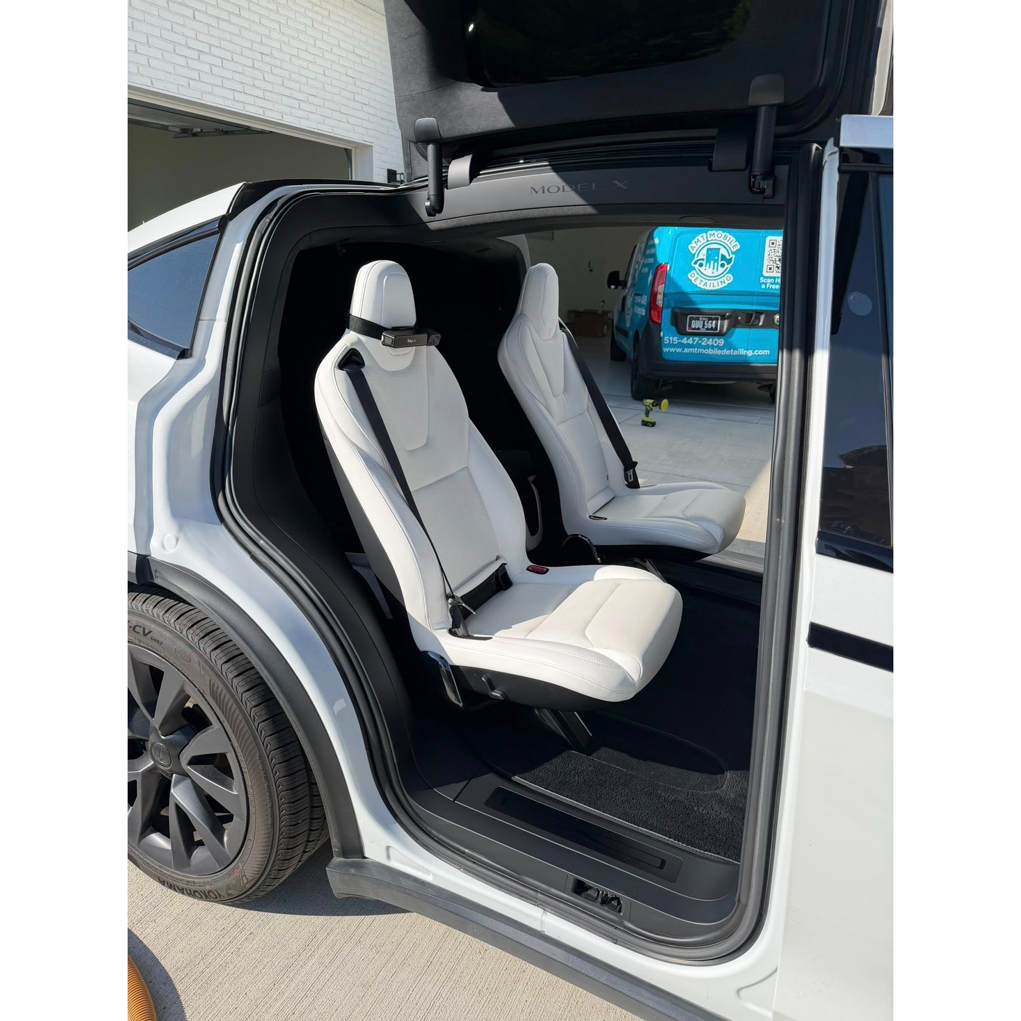 Clean white interior of a Tesla Model X after interior detailing, showing refreshed seats, clean door jambs, detailed floor areas, and professional cabin care.